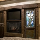 Typical room - Feature wall. Hand hewed timber entertainment center, complete with custom carved fish head accent. Copper engraved door panels, stain glass bar door, ceder closet interiors, antler handles on doors.